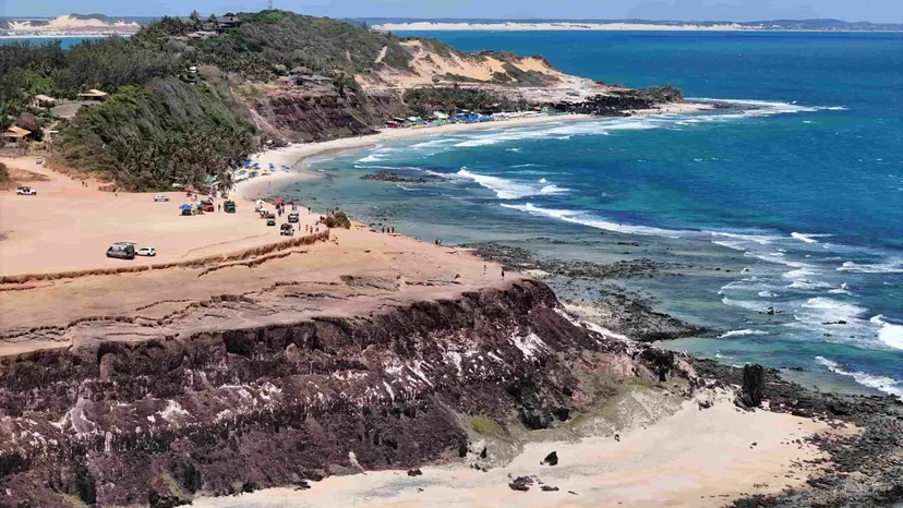 Vista aérea do Chapadão de Pipa com suas falésias avermelhadas e o mar azul em Tibau do Sul